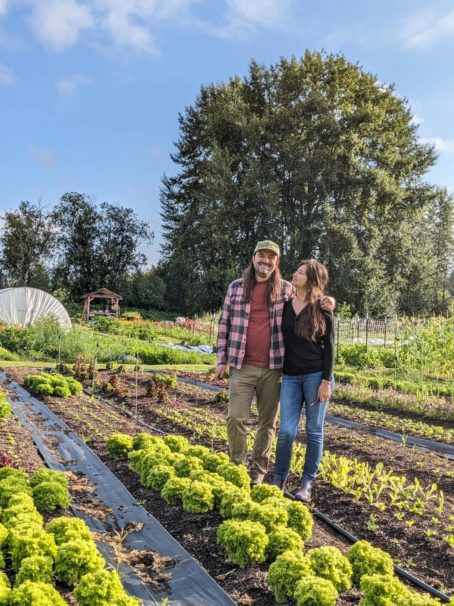 Tyler and Alex of Blue Glass Farm standing in the lettuce beds
